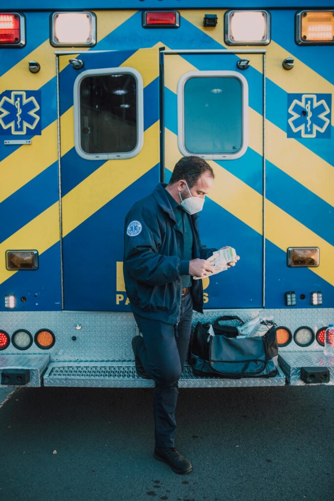 The Essentials of Blogging: Tips and Strategies for Success 2 Paramedic in uniform prepares medical equipment by ambulance outdoors.